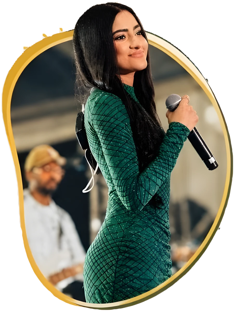Chathurya Sandabarana singing on stage in a green gown, holding a microphone